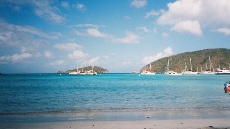 Caribbean beach with sailboats anchored offshore