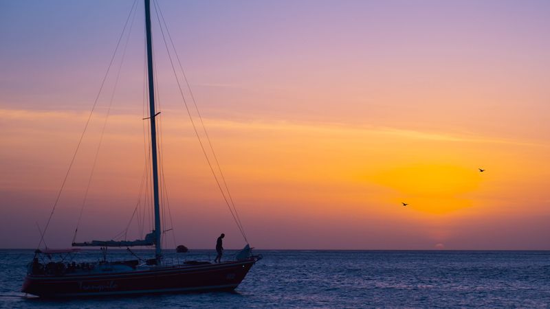 Sailboat silhouette against a Caribbean sunset
